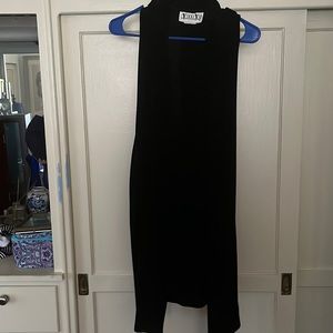 This is a black duster with black buttons. Perfect to wear with a dress or pants